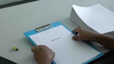 İş kadını ya da işveren ofisteki masasında özgeçmişine bakıyor..
