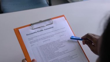 İş başvurusunda bulunan kişi kişilik değerlendirmesini kağıt formunda doldurmak üzere. Ofis tablosu.