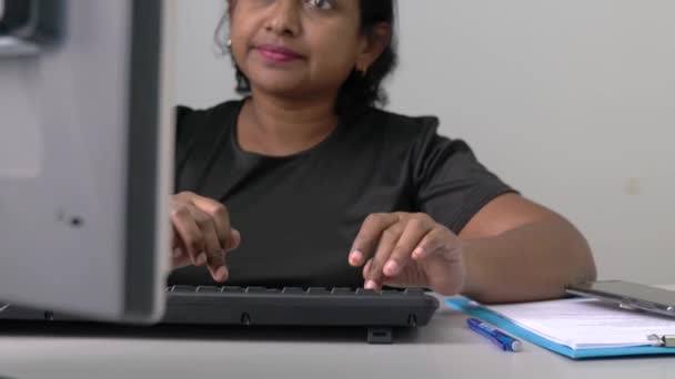 アジア系インド人の実業家がデスクトップコンピュータのキーボードを入力している 勤務地又は事務所の設定 — ストック動画