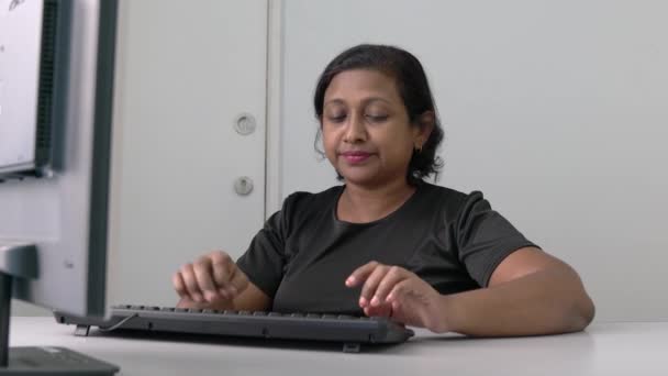 アジア系インド人の実業家がデスクトップコンピュータのキーボードを入力している 勤務地又は事務所の設定 — ストック動画