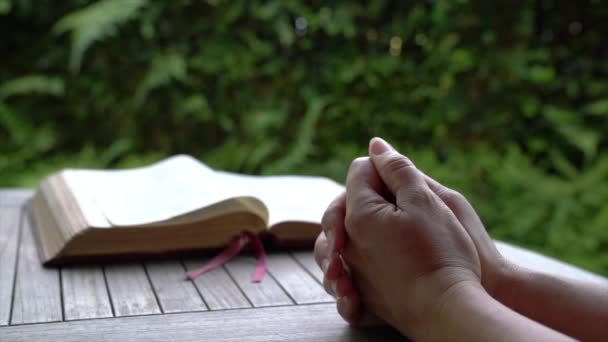 Vrouw Die Haar Handen Een Tafel Met Een Open Bijbel — Stockvideo