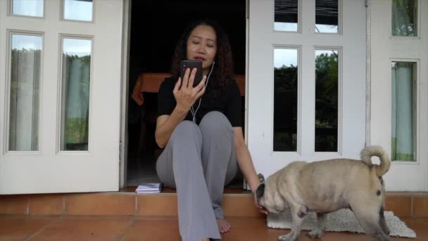Een Vrouw Die Haar Mobieltje Kletst Met Een Oortelefoon Thuisinstelling — Stockvideo