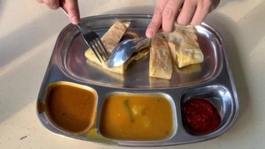 Roti canai yiyen adam, Malezya 'da kahvaltıda konforlu yemekler yiyen ünlü adam..