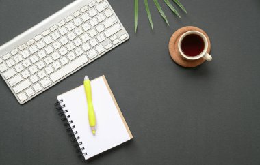Ofis masasının üst görüntüsü ya da düz klavye, kahve ve kalemli not defteri. Boşluğu kopyala.