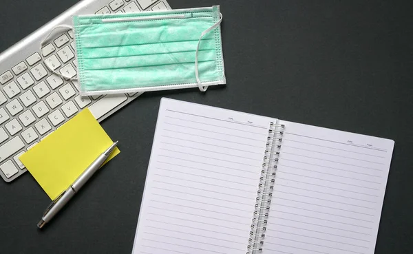 Kantoortafel Met Toetsenbord Notitieblok Pen Blanco Geel Papier Medisch Gezichtsmasker — Stockfoto