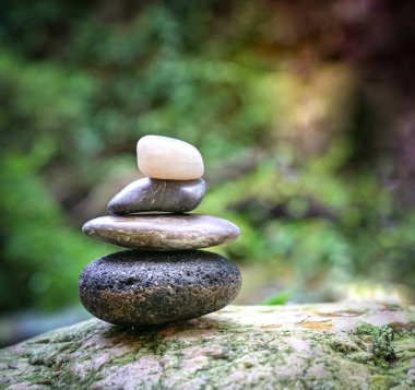 Yeşil doğa ve su arka planına sahip çakıl taşı kulesi. Zen, spa veya sağlık konsepti.