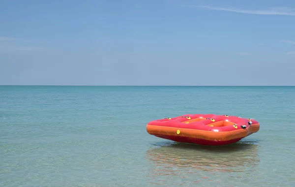 Red Inflatable ring or float in the blue sea with beautiful blue sky. Summer or holiday concept.