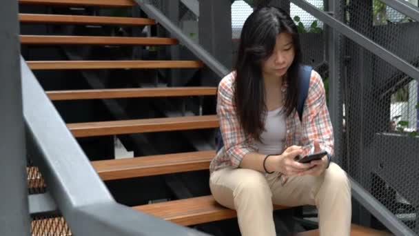 小女孩用手机发短信或上网 坐在楼梯上 — 图库视频影像