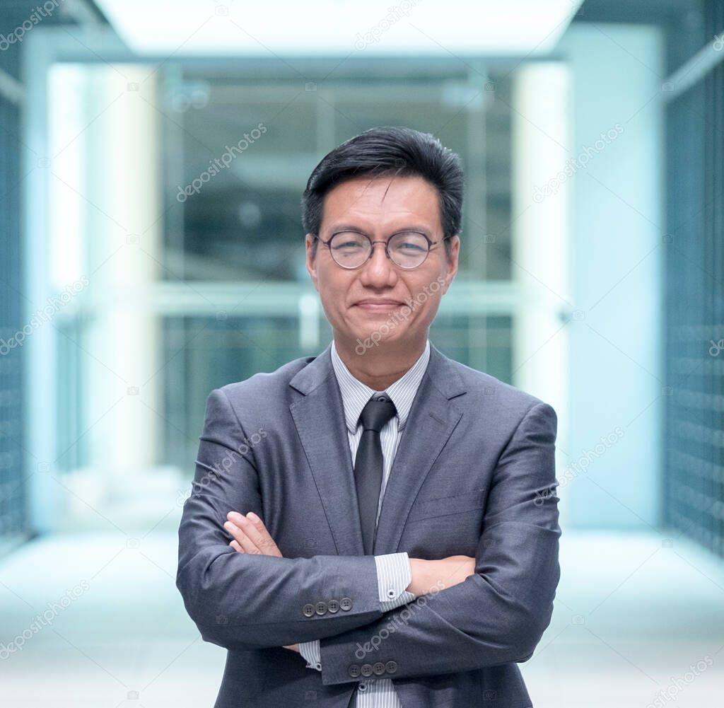 Portrait of a smiling Chinese businessman in business suit, looking at camera