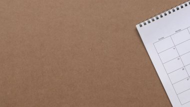 Kahverengi karton kağıtta beyaz takvim, kopyalama alanı. İş toplantısı, planlama ve hatırlatma konsepti.