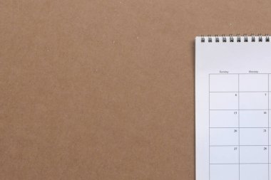 Kahverengi karton kağıtta beyaz takvim, kopyalama alanı. İş toplantısı, planlama ve hatırlatma konsepti.