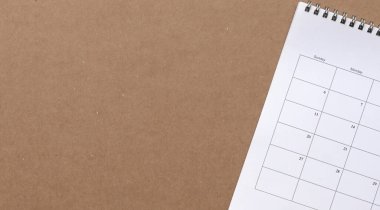 Kahverengi karton kağıt üzerinde takvim, kopyalama alanı. İş toplantısı, planlama ve hatırlatma konsepti.