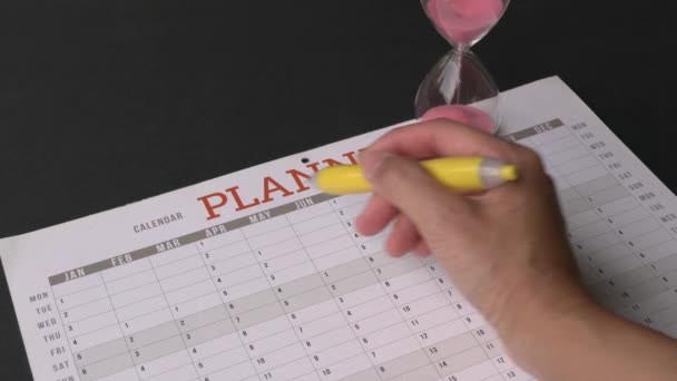 Kvinna Som Håller Penna Som Löper Genom Årlig Kalender Planerare — Stockvideo