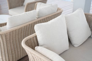 Outdoor rattan sofa on a wooden deck.
