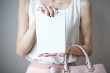 Bir kadının elindeki dijital elektronik tablet. Deri hafif pembe çanta, yaz zarif stili