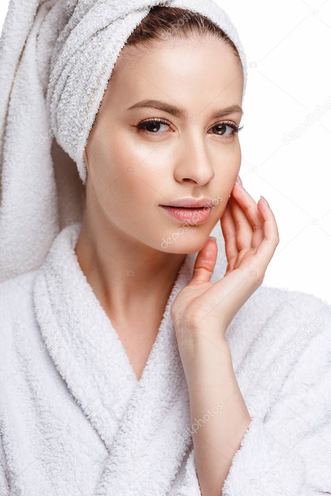 Young woman in a bathrobe and towel on her head, spa and care portrait, clean natural face, portrait on a white background isolated