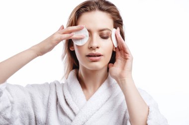 Bornozlu kadın yüz Pamuklu ped, spa ve bakım portre, temiz doğal yüz, portre izole beyaz bir arka plan üzerinde temizler