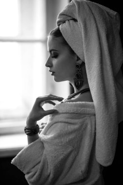 Genç kadın bir bornoz ve havlu onun kafa, moda takı, spa ve bakım portre, temiz doğal yüz, portre karanlık bir arka plan üzerinde