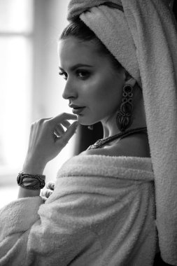 Genç kadın bir bornoz ve havlu onun kafa, moda takı, spa ve bakım portre, temiz doğal yüz, portre karanlık bir arka plan üzerinde