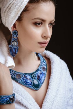 Genç kadın bir bornoz ve havlu onun kafa, moda takı, spa ve bakım portre, temiz doğal yüz, portre karanlık bir arka plan üzerinde