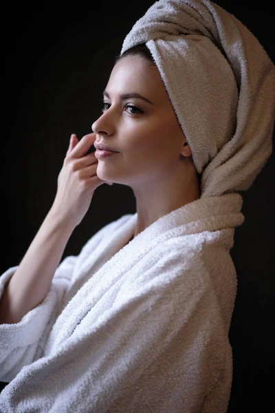 Stock image Young woman in a bathrobe and towel on her head, spa and care portrait, clean natural face