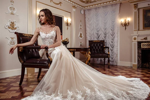 Sensual brunette bride in luxury wedding dress over classic interior, fashion beauty portrait