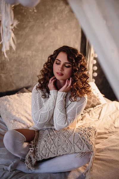 Pretty young woman in a room with christmas decoration. Winter mood, cozy home, scandinavian style