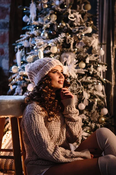 Pretty young woman in a room with christmas decoration. Winter mood, cozy home, scandinavian style