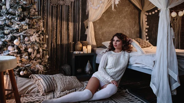 Pretty young woman in a room with christmas decoration. Winter mood, cozy home, scandinavian style