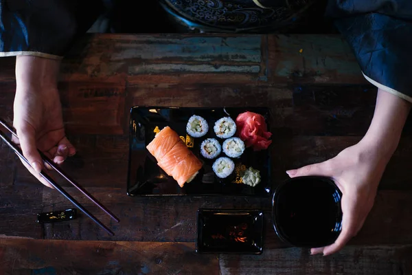 Nahaufnahme Foto Von Frauenhänden Mit Essstäbchen Die Sushi Rollen Essen — Stockfoto