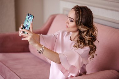 Güzel sarışın genç kadın ile hareket eden telefon. Rahat kıyafetler içinde güzel sarışın kız portresi.