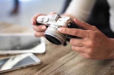 Genç kadın bir kompakt fotoğraf makinesi tutar