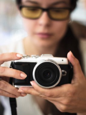 Genç kadın bir kompakt fotoğraf makinesi tutar