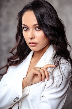 Güzel esmer kıvırcık ve kadın ile mükemmel cilt doğal makyaj closeup portresi. moda güzellik fotoğraf dokulu gri arka plan üzerinde