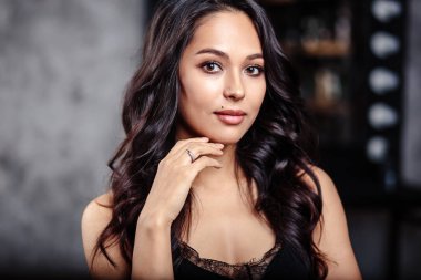 Güzel esmer kıvırcık ve kadın ile mükemmel cilt doğal makyaj closeup portresi. moda güzellik fotoğraf dokulu gri arka plan üzerinde