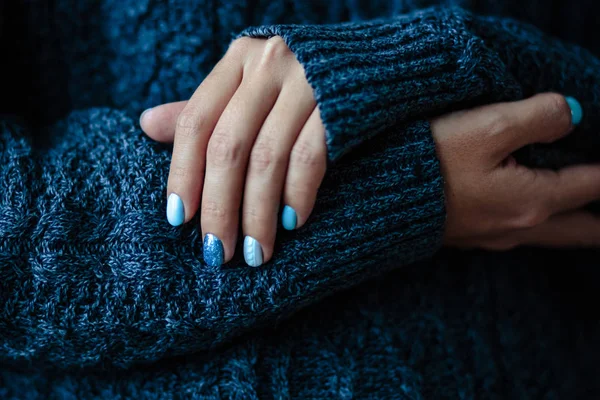 Gorgeous manicure, pastel tender blue color nail polish, closeup photo. Female hands over simple background