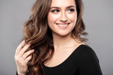 Esmer kız sağlıklı kıvırcık saçlı ve doğal makyaj. Güzel model kadınla dalgalı saç modeli. Bakım ve güzellik