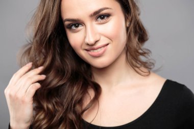 Esmer kız sağlıklı kıvırcık saçlı ve doğal makyaj. Güzel model kadınla dalgalı saç modeli. Bakım ve güzellik