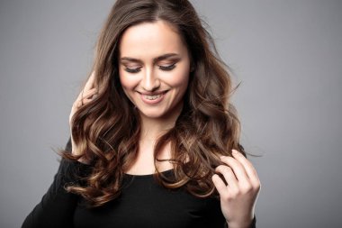 Esmer kız sağlıklı kıvırcık saçlı ve doğal makyaj. Güzel model kadınla dalgalı saç modeli. Bakım ve güzellik