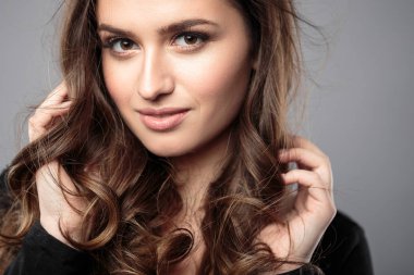 Esmer kız sağlıklı kıvırcık saçlı ve doğal makyaj. Güzel model kadınla dalgalı saç modeli. Bakım ve güzellik