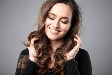 Esmer kız sağlıklı kıvırcık saçlı ve doğal makyaj. Güzel model kadınla dalgalı saç modeli. Bakım ve güzellik