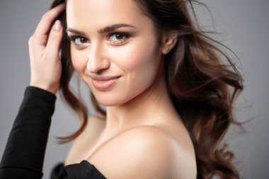Esmer kız sağlıklı kıvırcık saçlı ve doğal makyaj. Güzel model kadınla dalgalı saç modeli. Bakım ve güzellik