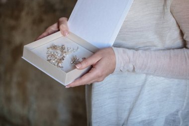 Beyaz boş kutu içinde el yapımı takı düğün ile kadının ellerini tutun