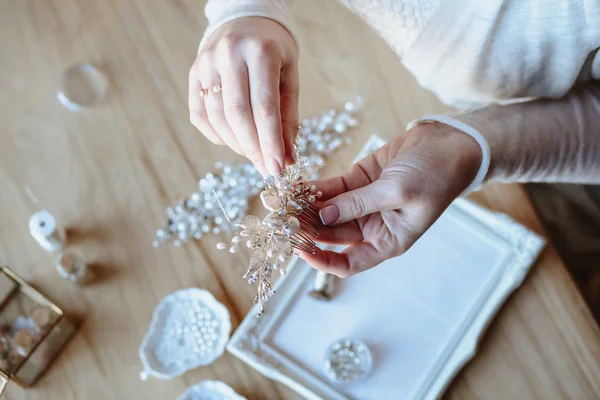 Closeup macro photo of details, workplace of decorator and creator of wedding imitation jewelry. Woman\'s hands in a process of creation