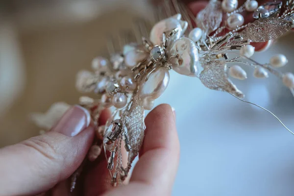 Closeup macro photo of details, workplace of decorator and creator of wedding imitation jewelry. Woman\'s hands in a process of creation