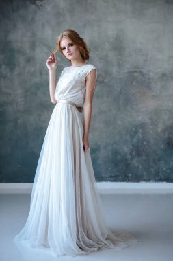 Zarif saç tarzı ile modern bir renk gelinlik gelin sarışın kadın ve makyaj. Dokulu arka plan üzerinde moda güzellik portre