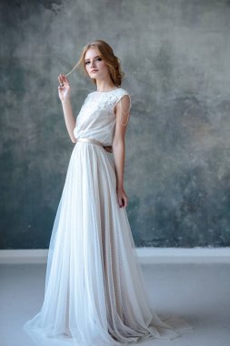 Zarif saç tarzı ile modern bir renk gelinlik gelin sarışın kadın ve makyaj. Dokulu arka plan üzerinde moda güzellik portre