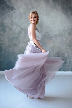 Zarif saç tarzı ile modern bir renk gelinlik gelin sarışın kadın ve makyaj. Dokulu arka plan üzerinde moda güzellik portre