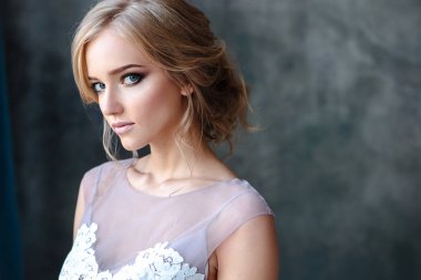 Zarif saç tarzı ile modern bir renk gelinlik gelin sarışın kadın ve makyaj. Dokulu arka plan üzerinde moda güzellik portre