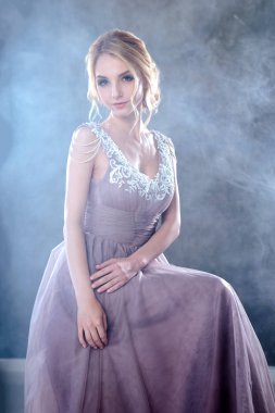 Zarif saç tarzı ile modern bir renk gelinlik gelin sarışın kadın ve makyaj. Dokulu arka plan üzerinde moda güzellik portre